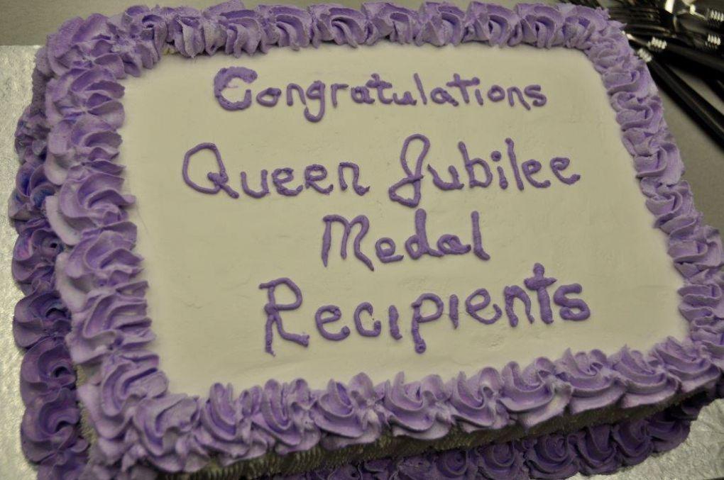 Cake with purple icing congratulating Queen Jubilee Medal recipients.