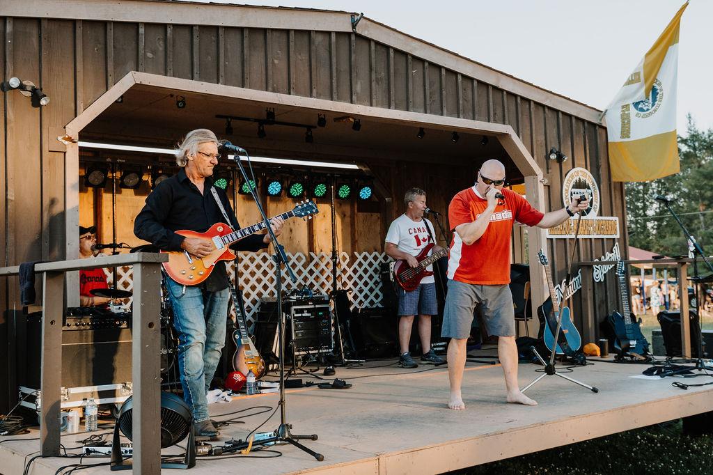 three rock band members performing on a stage
