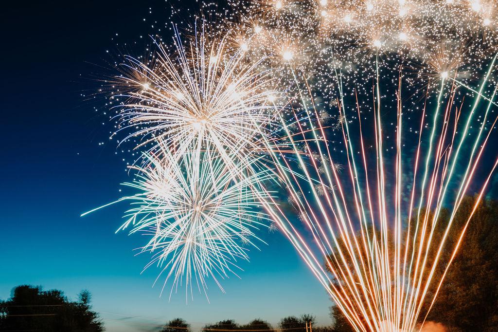 fireworks display against a fading night sky