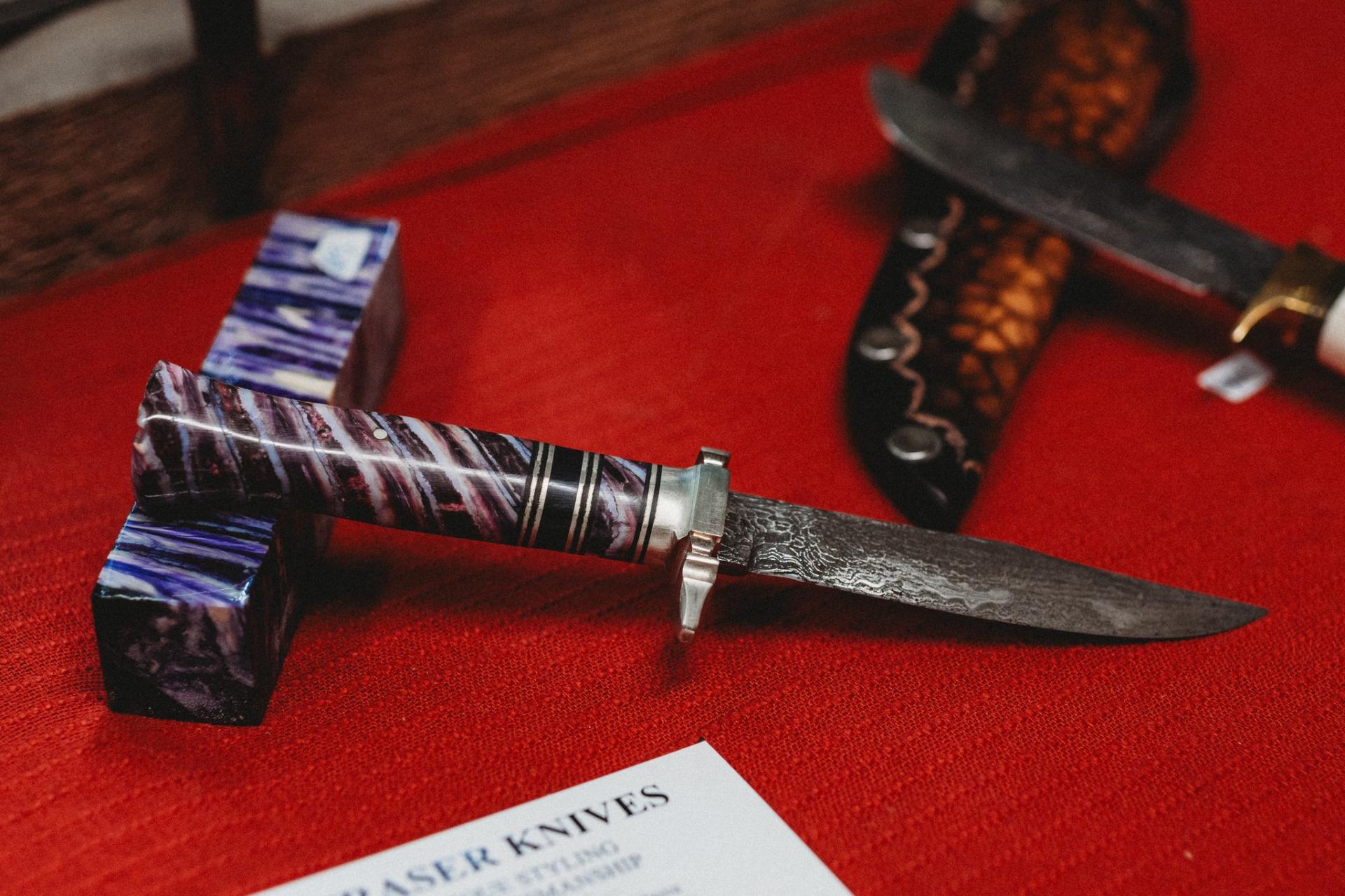 purple handle knife sitting on a red tabletop