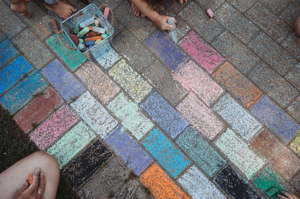 hand holding chalk colouring blocks on sidewalk